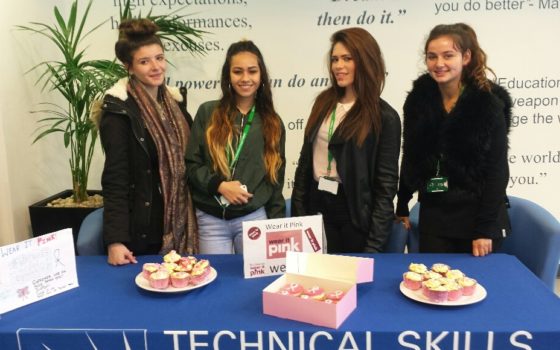 Hair and beauty students on the wear it pink cake stall at the technical skills academy