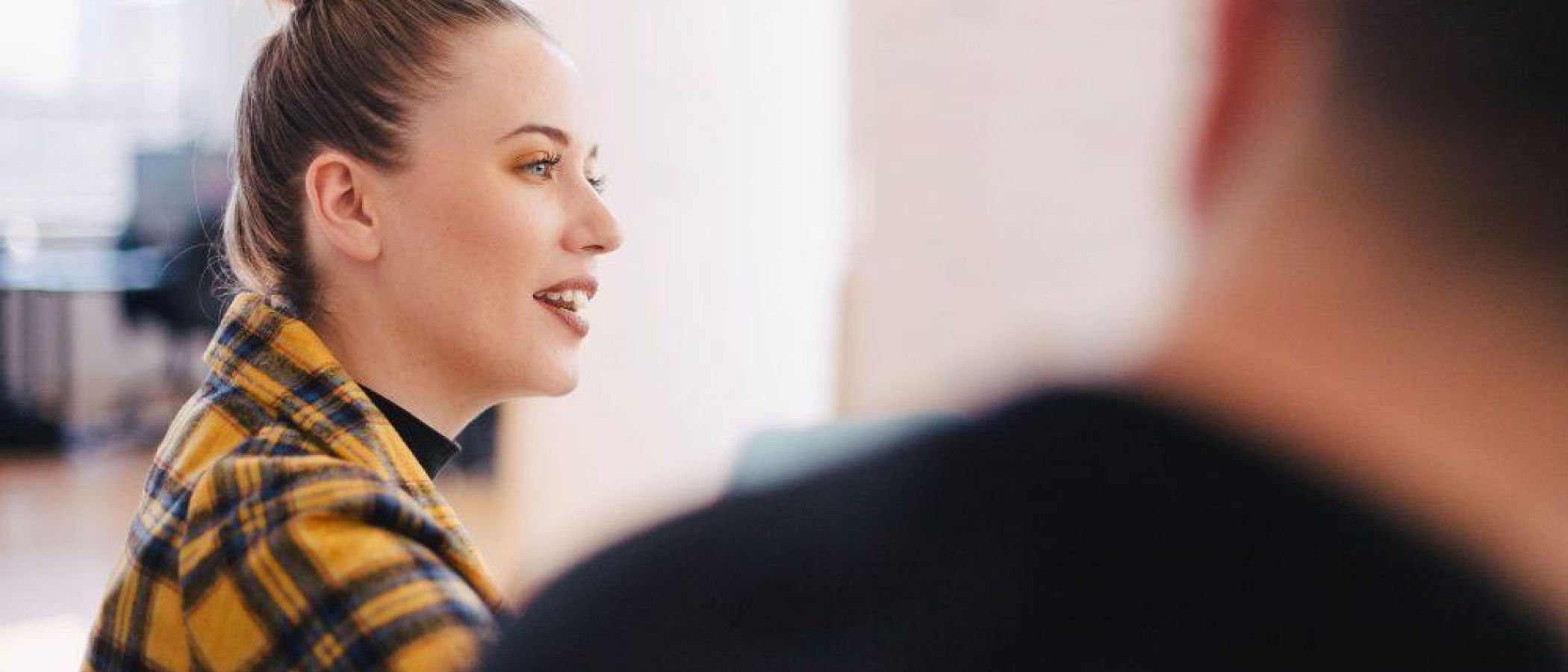 women in work environment with laptop speaking in a meeting