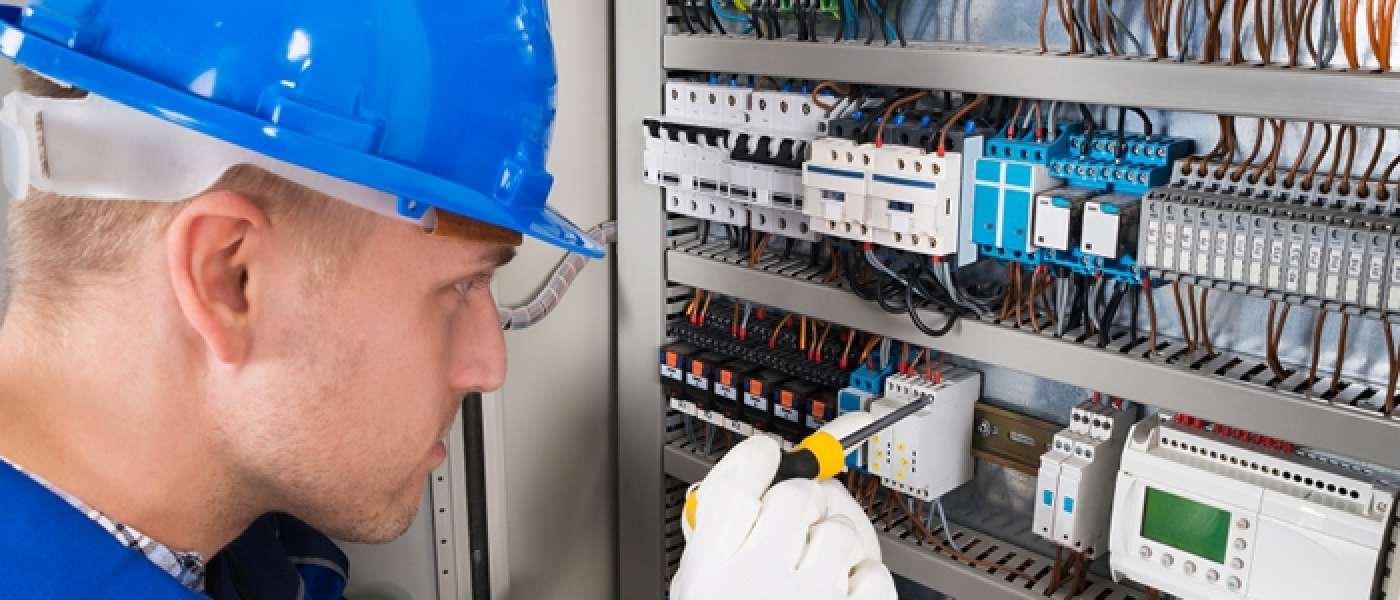 male wearing hardhat working on electrical board