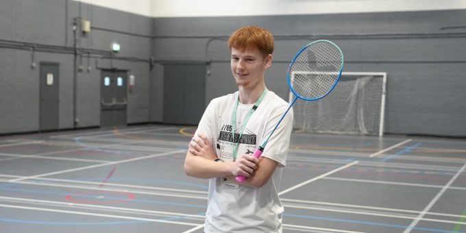 Sport student stood holding badminton racket